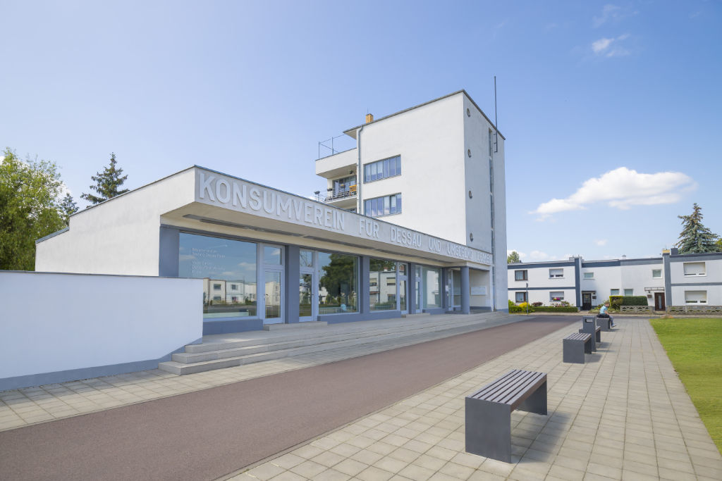 Vorplatz Konsumgebäude Dessau mit Sitzmöglichkeiten und Grünfläche